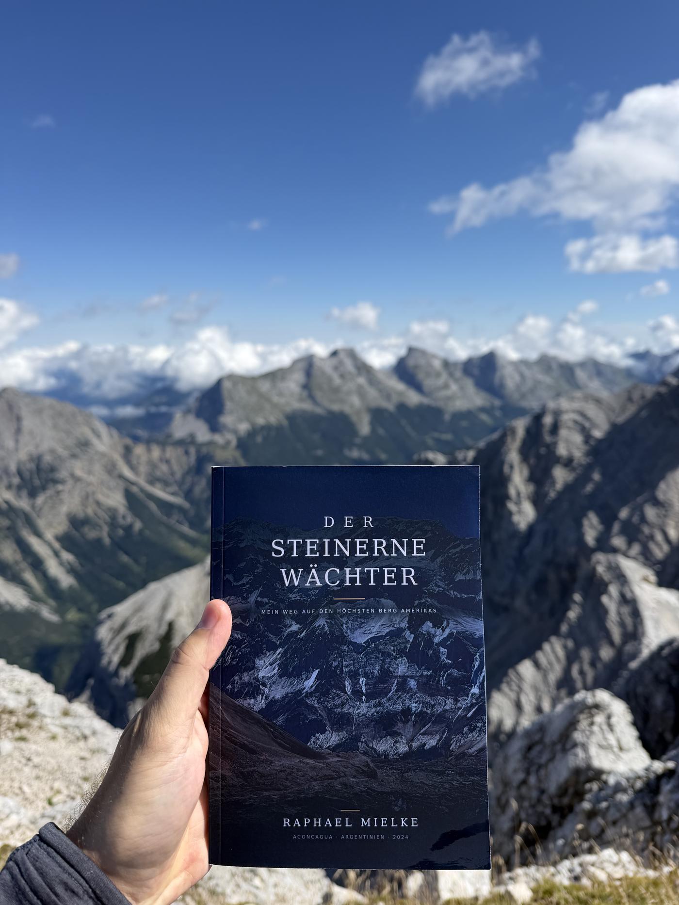 Das Taschenbuch Der steinerne Wächter, in den Bergen in der Hand gehalten