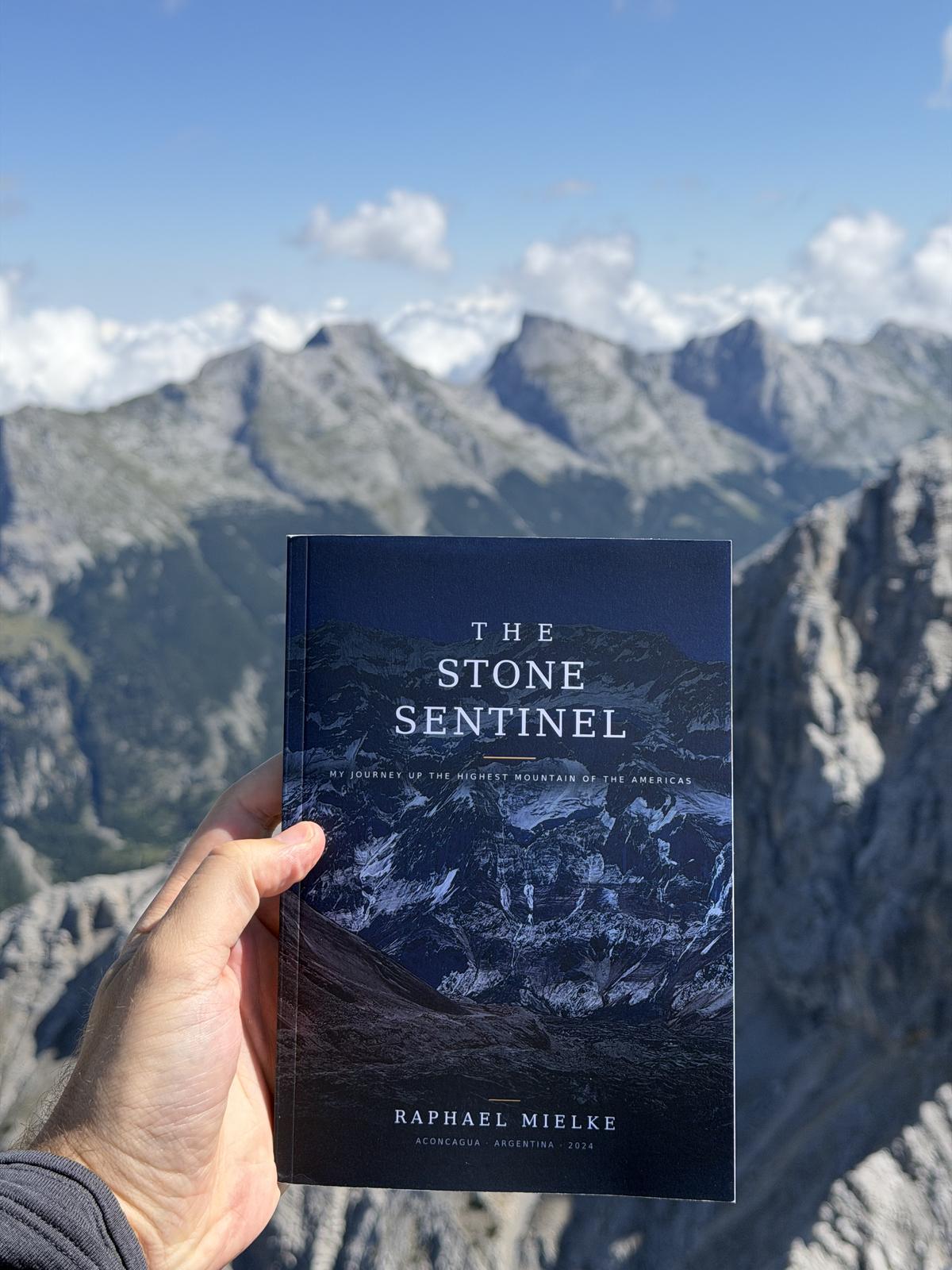 The Stone Sentinel paperback held up in the mountains